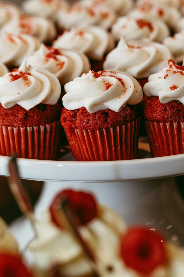 Close-up of red velvet cupcakes topped with rich cream cheese frosting, perfect for any celebration.